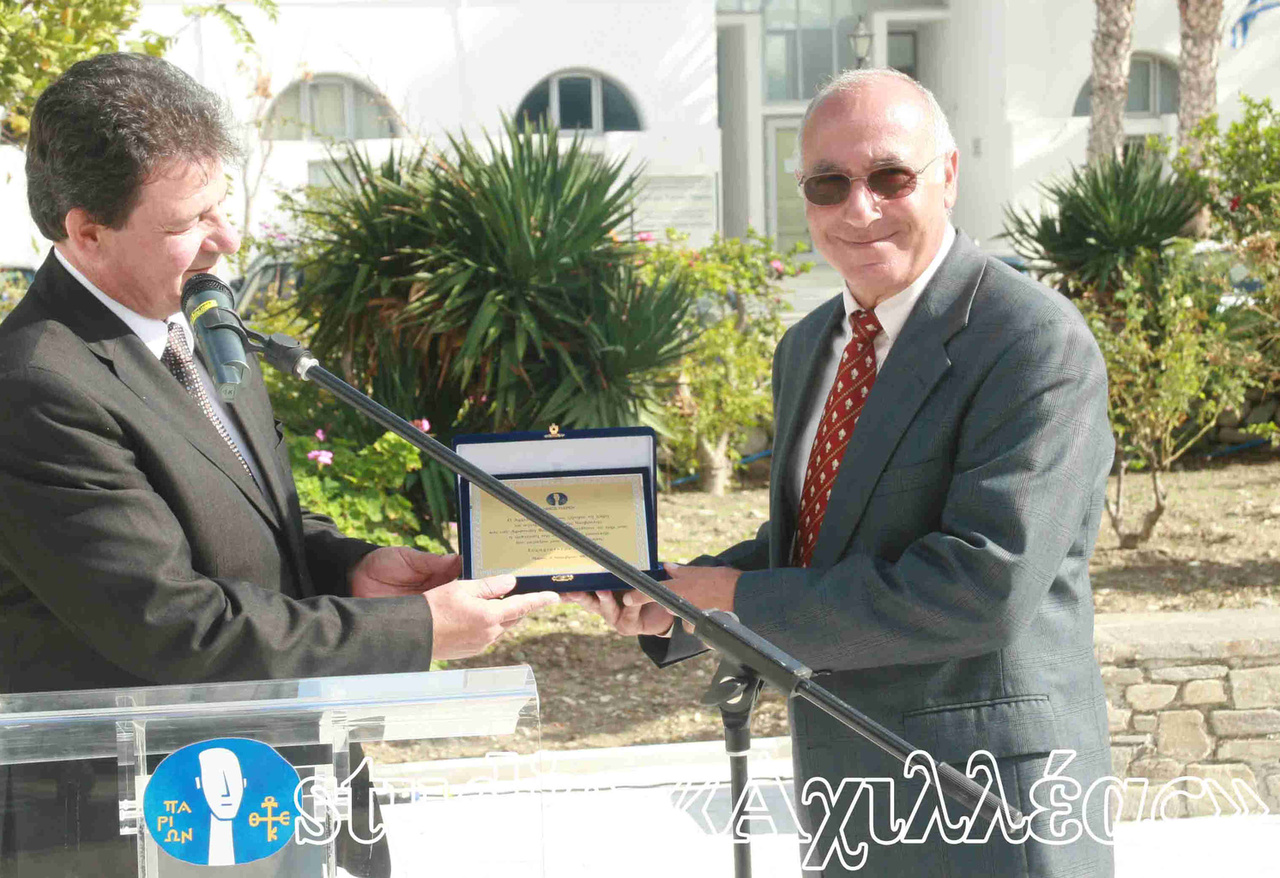 Πάρος 2009. Ο Δήμαρχος Παρίων κ. Χ. Βλαχογιάννης παραδίδει πλακέτα στο γλύπτη Α. Βαρριά κατά τα αποκαλυπτήρια της προτομής του Αρχιλόχου.